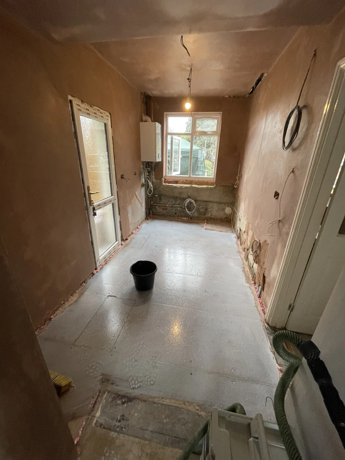 Room with freshly prepared floor and walls during renovation