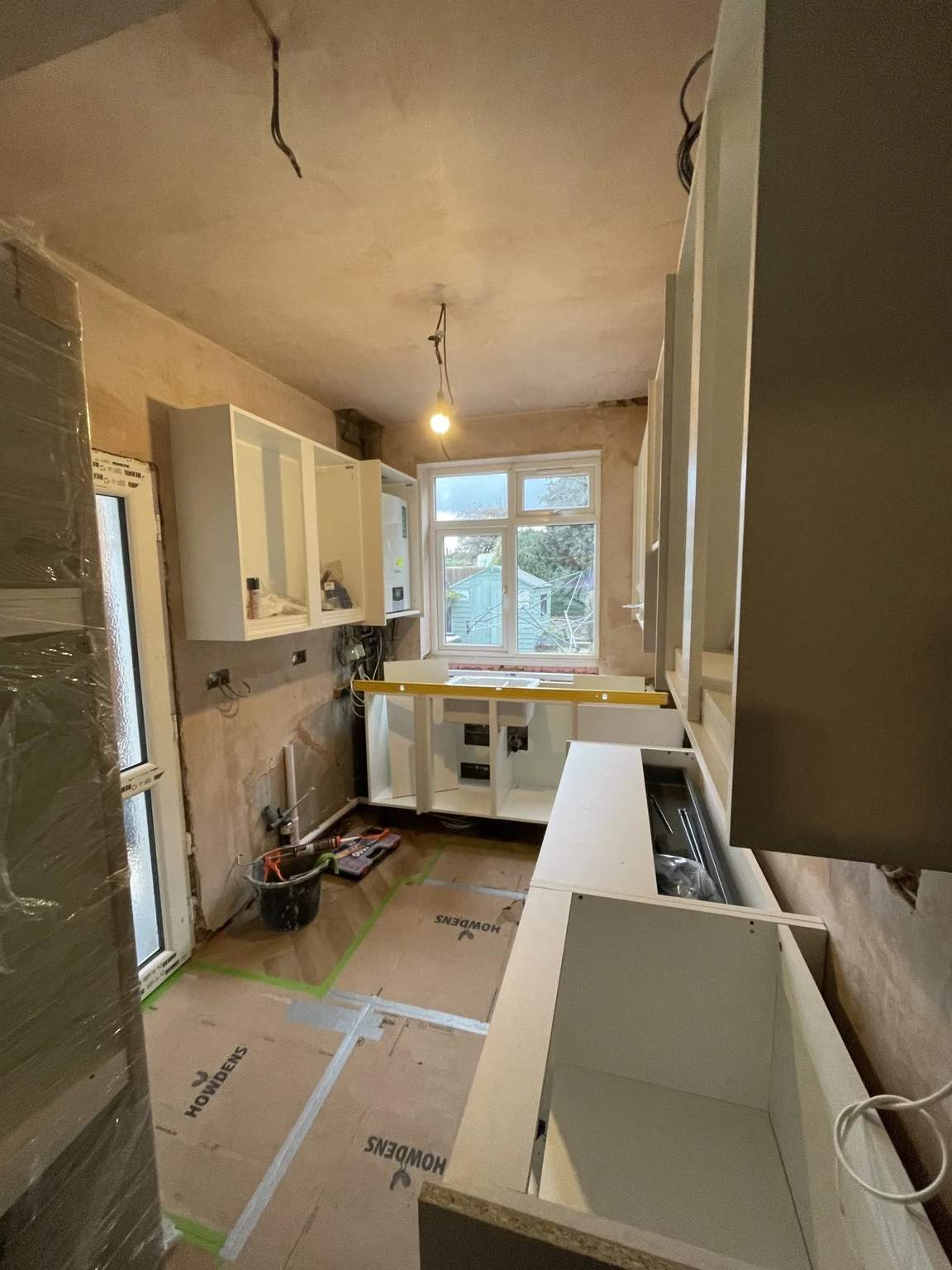 Kitchen units being installed in a room under renovation