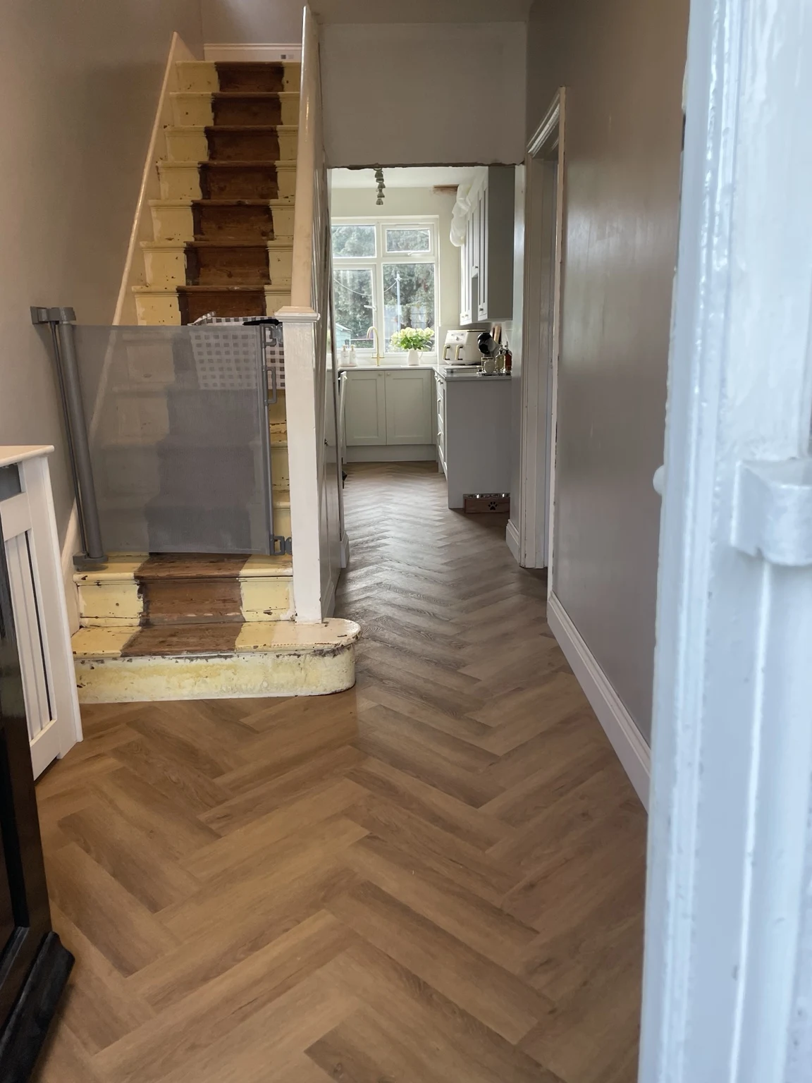 Herringbone hallway flooring and staircase during renovation